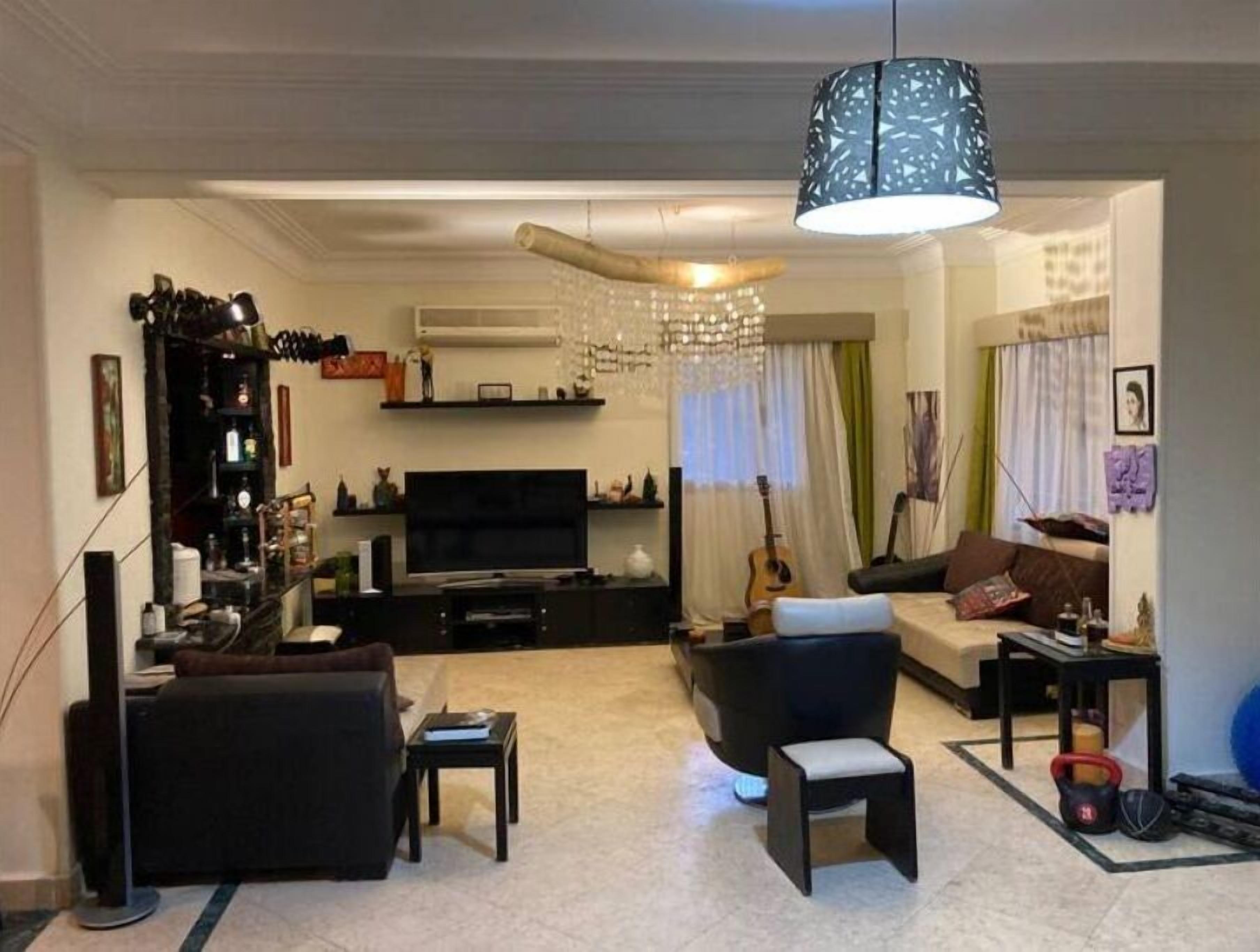 A living room with a TV, sofa, and a small table.