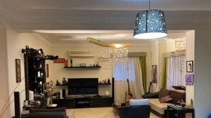 Een woonkamer met een televisie, bank en een klein tafeltje.