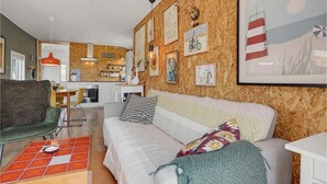 A cozy living room with a sofa, a coffee table, and a kitchen in the background. - Beautiful home in Haderslev with WiFi (Haderslev)
