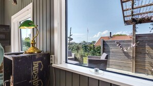 A room with a window overlooking a garden, a vintage lamp, and a wooden bench. - Beautiful home in Haderslev with WiFi (Haderslev)