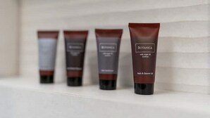 Vier Flaschen Botanica Bath & Shower Gel auf einem Regal.