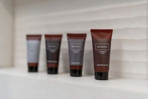 Four bottles of Botanica Bath & Shower Gel on a shelf. - KING-BED Lux VRBO w/AC&free ‌ in Karlín! Suite 1 (Praha)
