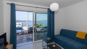 Una sala de estar moderna con un sofá, una mesita y un televisor.