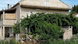 Un edificio a due piani con un giardino antistante.