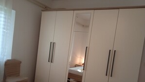 Una camera da letto con un armadio grande, un letto e una sedia.