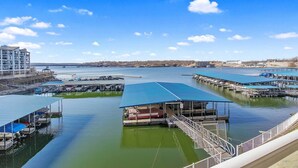 Een jachthaven met steigers, een overdekte helling voor boten en een gebouw met een blauw dak.