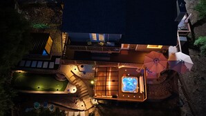 Vista aérea de una casa con jacuzzi, zona de estar al aire libre y una piscina pequeña.