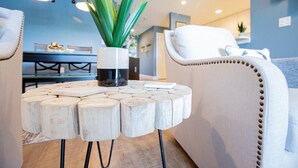 A modern living room with a round wooden coffee table, a potted plant, and a white sofa. - WaterFront Getaway Parkview Bay! Lux Condo 3Pools! (Osage Beach)