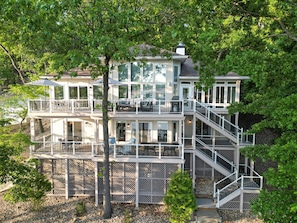 Une maison à plusieurs niveaux dotée d’un balcon, d’un escalier et d’une terrasse.