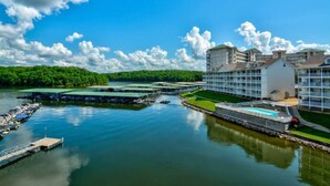 A waterfront hotel with multiple buildings, a dock, and a swimming pool.