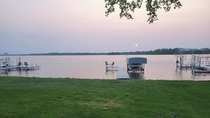 A lakeside deck with a boat dock, grassy area, and a clear view of the water. - Tradewinds on Cormorant, Audubon, MN (Audubon)