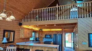 A spacious cabin interior with a kitchen, dining area, and a balcony. - Tradewinds on Cormorant, Audubon, MN (Audubon)
