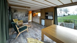 Ett kompakt bostadsutrymme med matplats, kök och utsikt över omgivningarna.