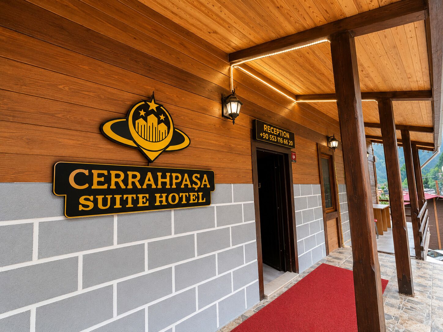 A hotel entrance with a reception desk, a red carpet, and a sign for the 'CERRAHPASA SUITE HOTEL'.