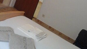 Een hotelkamer met een bed, een houten stoel en een deur.