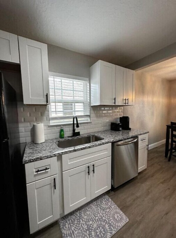 Enjoy cooking in this well-equipped kitchen with a stainless steel dishwasher and granite countertop.