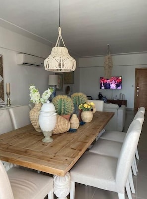 A dining area with a wooden table, white chairs, and decorative vases.