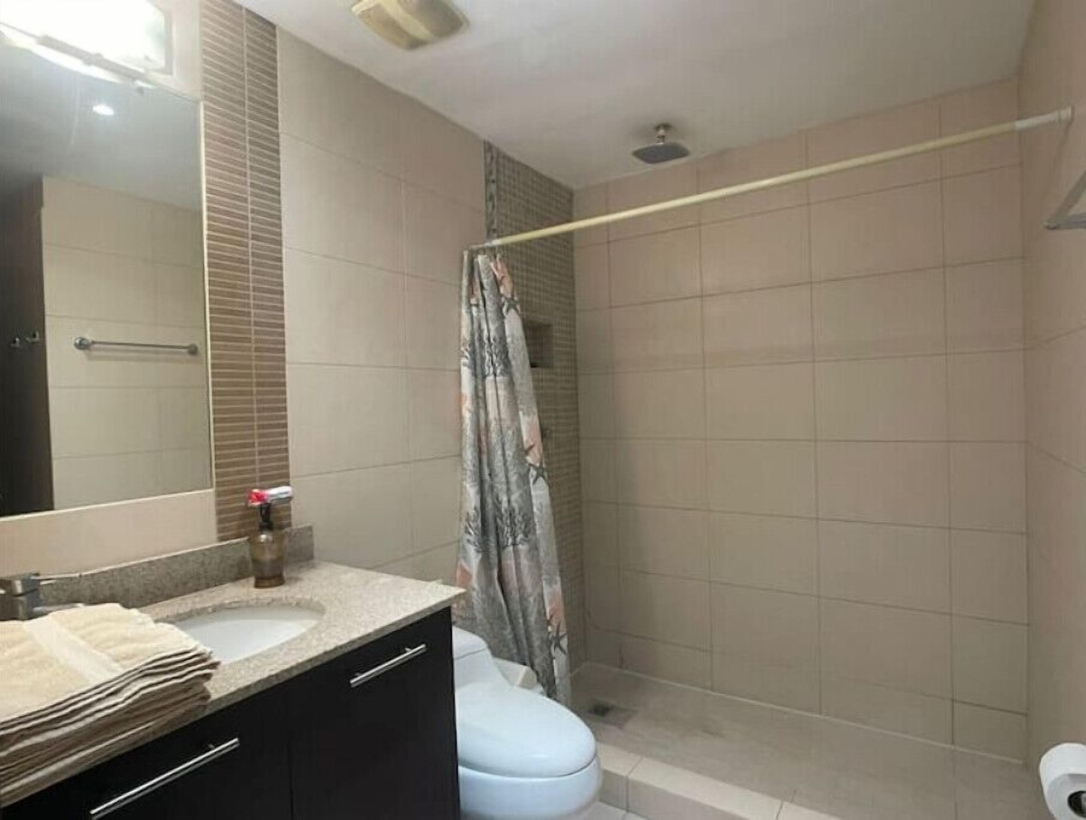 Baño con ducha, inodoro y lavabo.