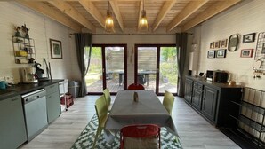 Une cuisine avec une table à manger, des chaises et une vue sur l’extérieur.