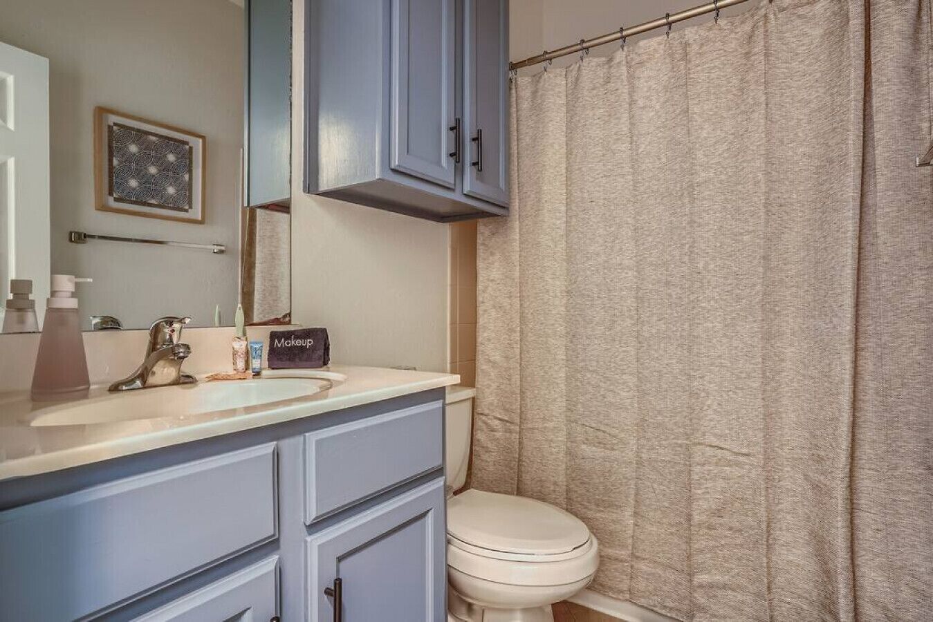 Un baño con lavamanos, espejo y retrete.