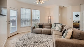A living room with a sectional sofa, a patterned rug, and a ceiling fan. - Spacious 6-bedroom Duplex  w/Pool Mins FC Stadium / Domain (Austin)