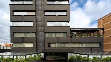 A modern building with a symmetrical facade, large windows, and a flat roof.
