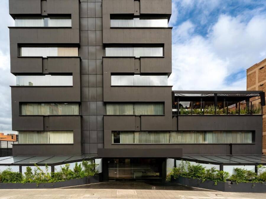 A modern building with a symmetrical facade, large windows, and a flat roof.