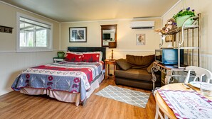 Un dormitorio acogedor con cama, escritorio, silla y televisor.