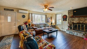 A cozy living room with a fireplace, leather sofas, and a stone fireplace surround. - Private Hot Tub & Covered Deck: Cozy Whittier Gem (Whittier)