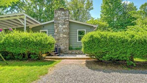 A house with a stone chimney, a covered porch, and a gravel driveway. - Private Hot Tub & Covered Deck: Cozy Whittier Gem (Whittier)