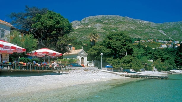 A beach with clear turquoise water, a white sandy shore, and a backdrop of green hills. - Apartments and Rooms Jokovic-standard Studio Apartment With Terrace and Partial Sea View (Zupa dubrovacka)