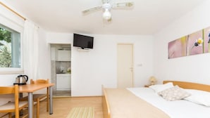 A bedroom with a bed, a desk, a chair, a television, and a window. - Apartments and Rooms Jokovic-standard Studio Apartment With Terrace and Partial Sea View (Zupa dubrovacka)