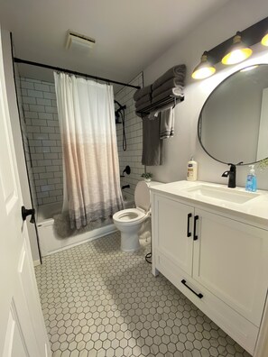 A bathroom with a white sink, a toilet, a shower with a curtain, and a mirror with lights. - Crescent Bar Condo near The Gorge, Boating & Golf. Sleeps 8. AMAZING Pool.  (Quincy)