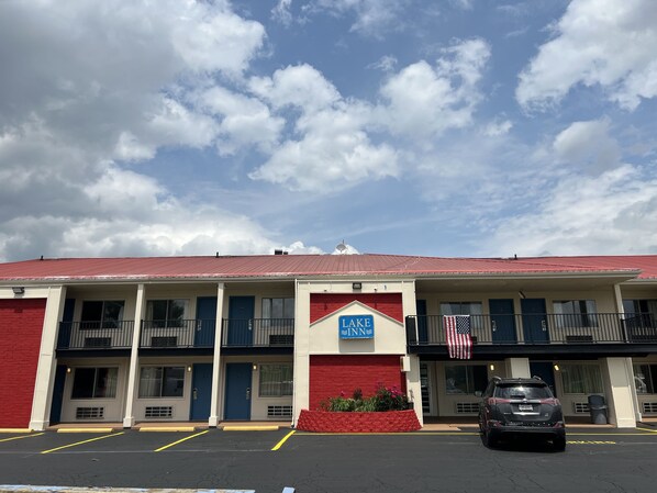 A motel with a red roof, a sign reading "LAKE INN," and a parking lot with a car. - LAKE INN (Buckeye Lake)