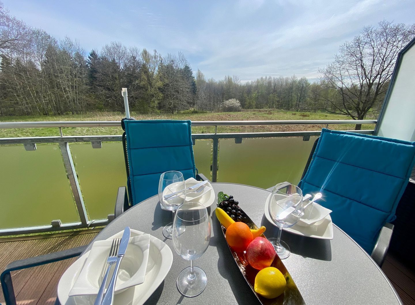 Mesa para dos con vista a una masa de agua verde y árboles al fondo.