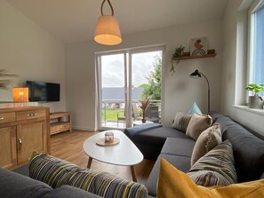 Een moderne woonkamer met een bank, een salontafel en een televisie.