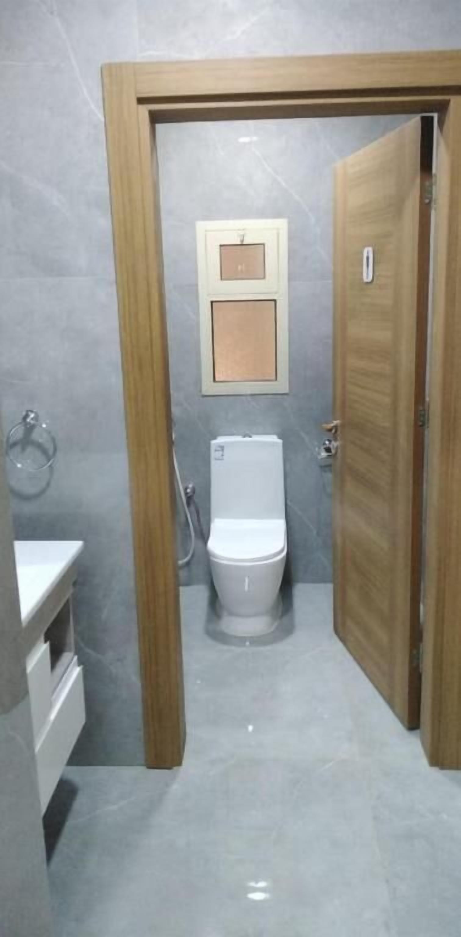 A bathroom with a toilet, a shower, and a sink.