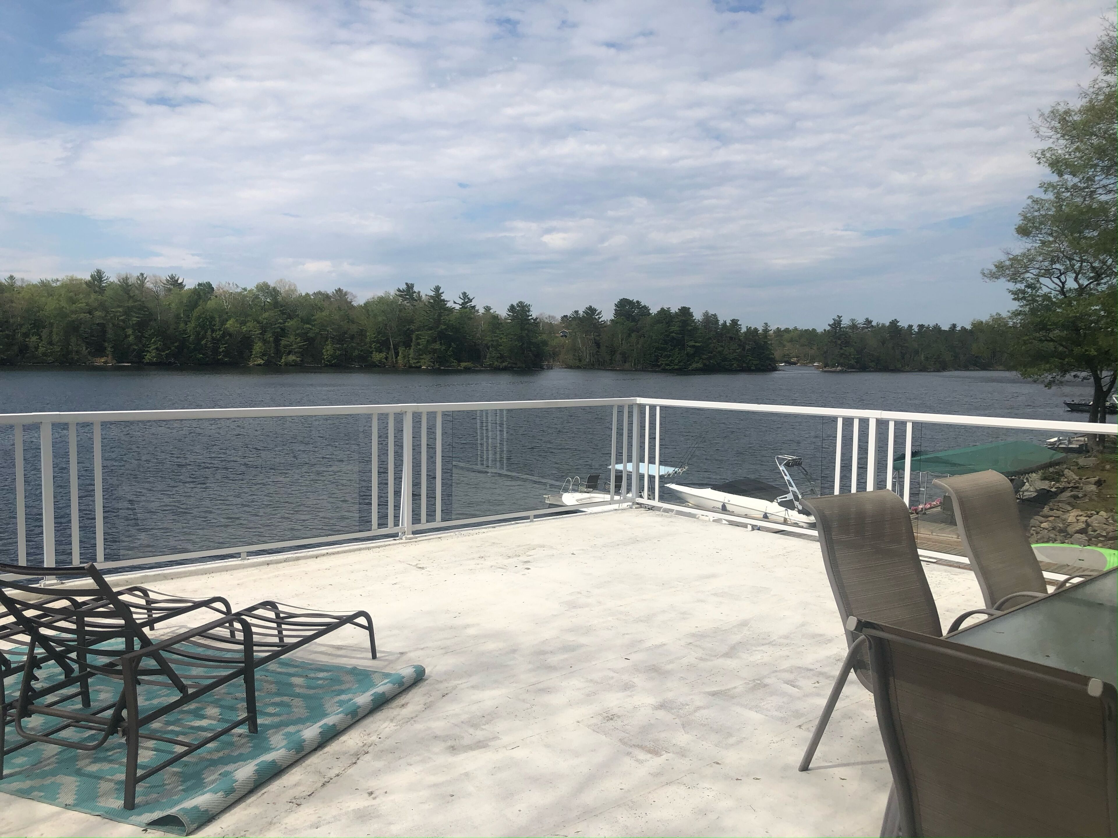 Una terraza con vistas a un lago, rodeada de árboles.