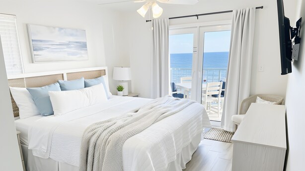 A hotel room with a bed, a desk, and a view of the sea. - Uncrowded Corner Beachfront 3BR w/3 New Spa Baths (Gulf Shores)