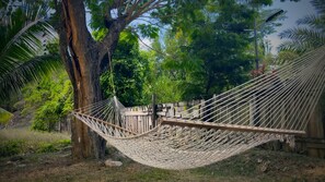 A hammock tied between trees in a natural setting. - The Nest Villa - Sleeps 16, 5BR Family Pool, Swings, BBQ, Gated Estate (Canaan, Tobago)
