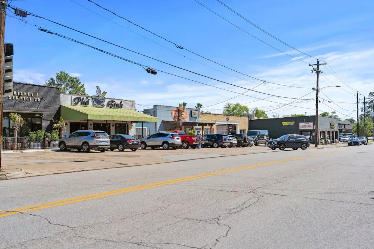 A street view with various businesses, including a restaurant with a green awning and a sign that reads "Piko Biko."