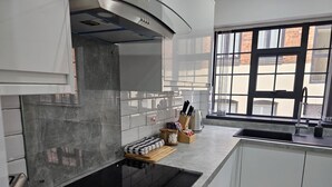 Una cocina moderna con un amplio ventanal, electrodomésticos de acero inoxidable y un diseño limpio y minimalista.