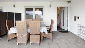 A dining area with wicker furniture and a tiled floor.