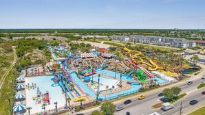 A large water park with multiple slides and pools, surrounded by roads and buildings. - Renovated Condo: 3 Min Beach Walk (Destin)