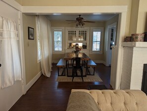 Cozy living and dining area with a fireplace, dining table, and large window.