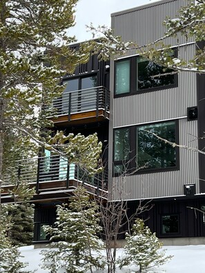 A modern multi-story building with balconies and large windows.