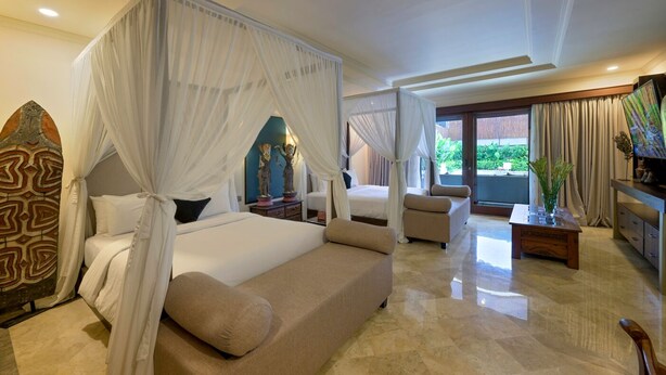 A spacious bedroom with a four-poster bed, a sofa, and a television. - villa deh simba at seminyak oberoi  (Seminyak)
