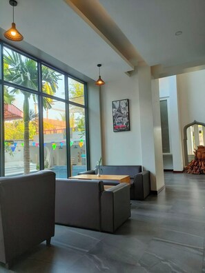 A modern interior with large windows, a pool, and a seating area.