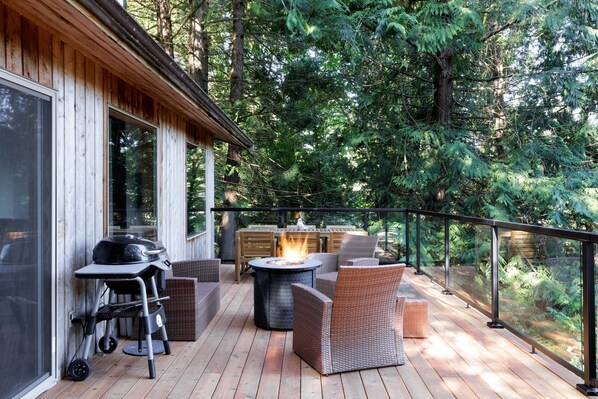 Enjoy al fresco dining and socializing on this spacious deck surrounded by lush greenery.