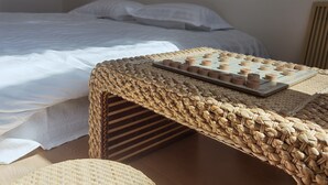 A neatly made bed with white linens, a woven table with a board game, and a wooden headboard. - Shanyutianyuan (Huairou)